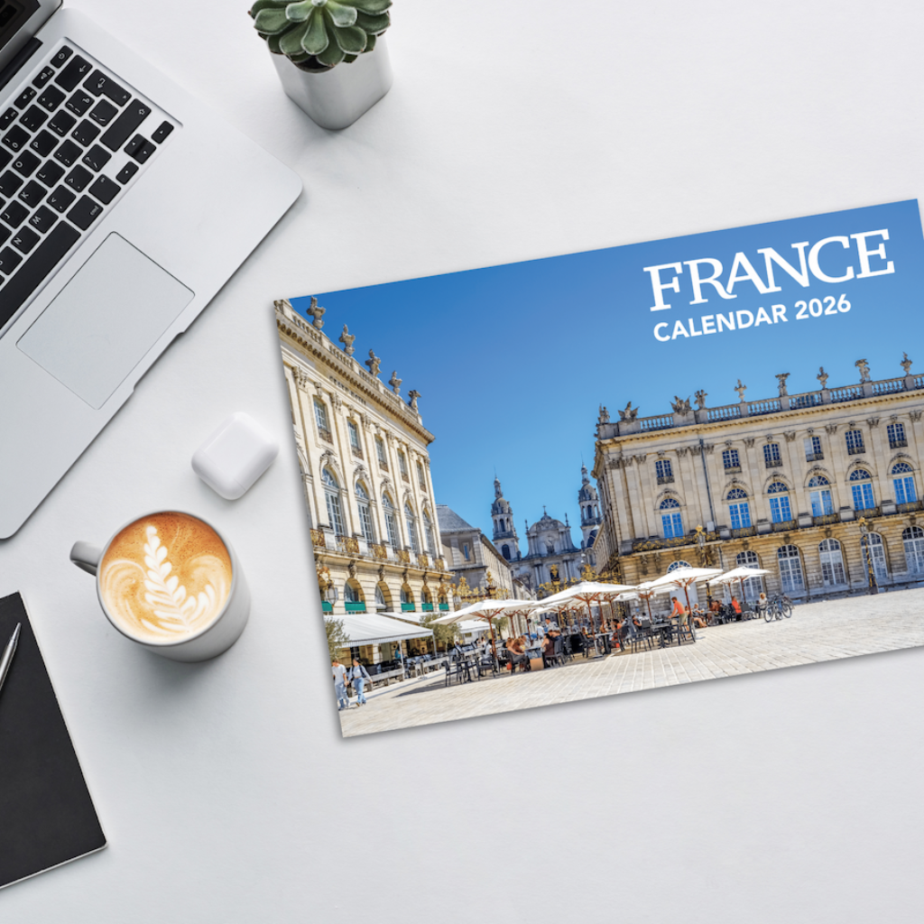 Calendar for 2026 featuring a scenic view of a French building on a desk with a laptop and coffee.